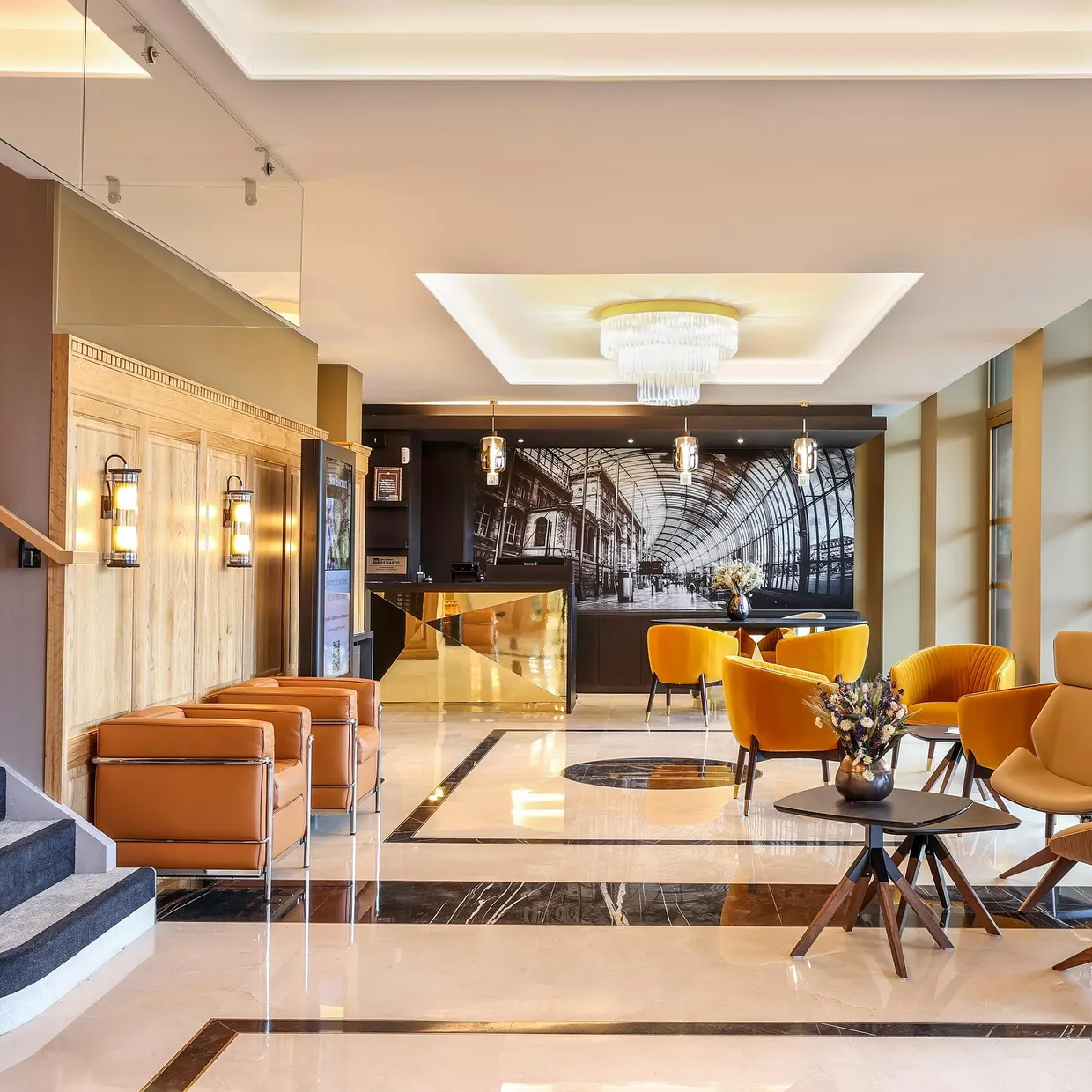 Lobby d'hôtel avec des canapés et des fauteuils, une réception et un escalier sur le côté