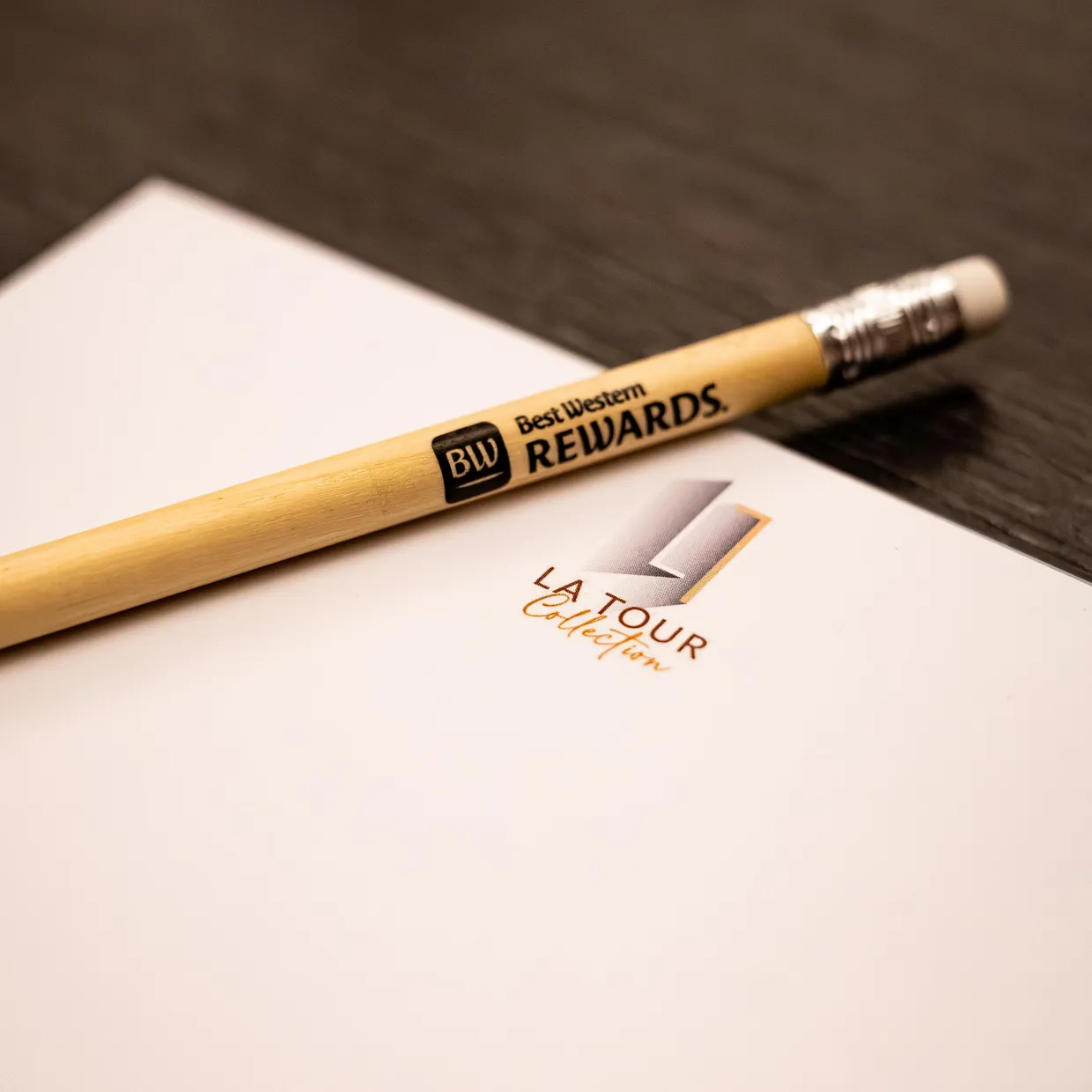 Un crayon Best Western Rewards posé sur une feuille de papier avec le logo "LA TOUR Collection"