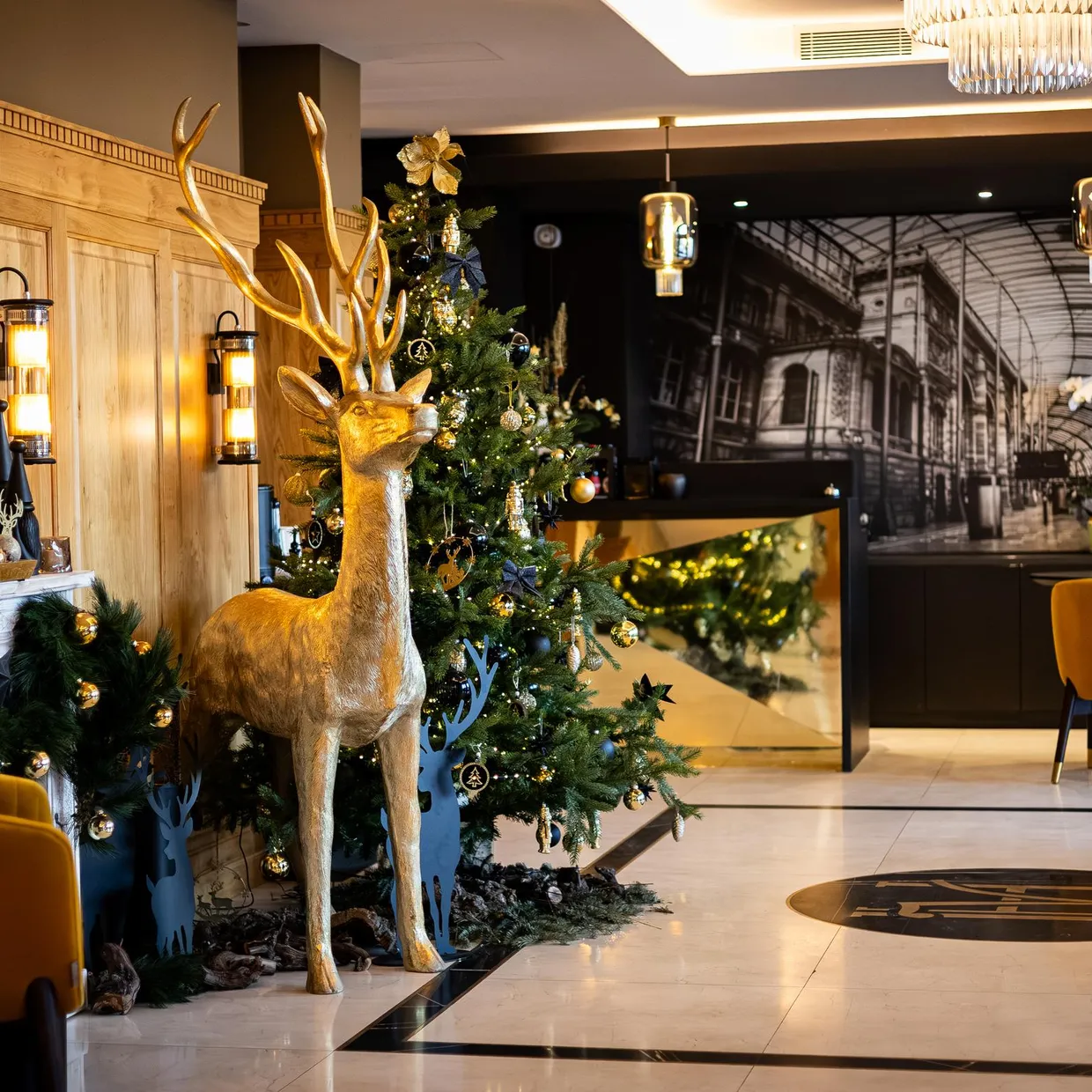 Un intérieur décoré pour Noël avec un sapin, un cerf doré et des sièges jaunes