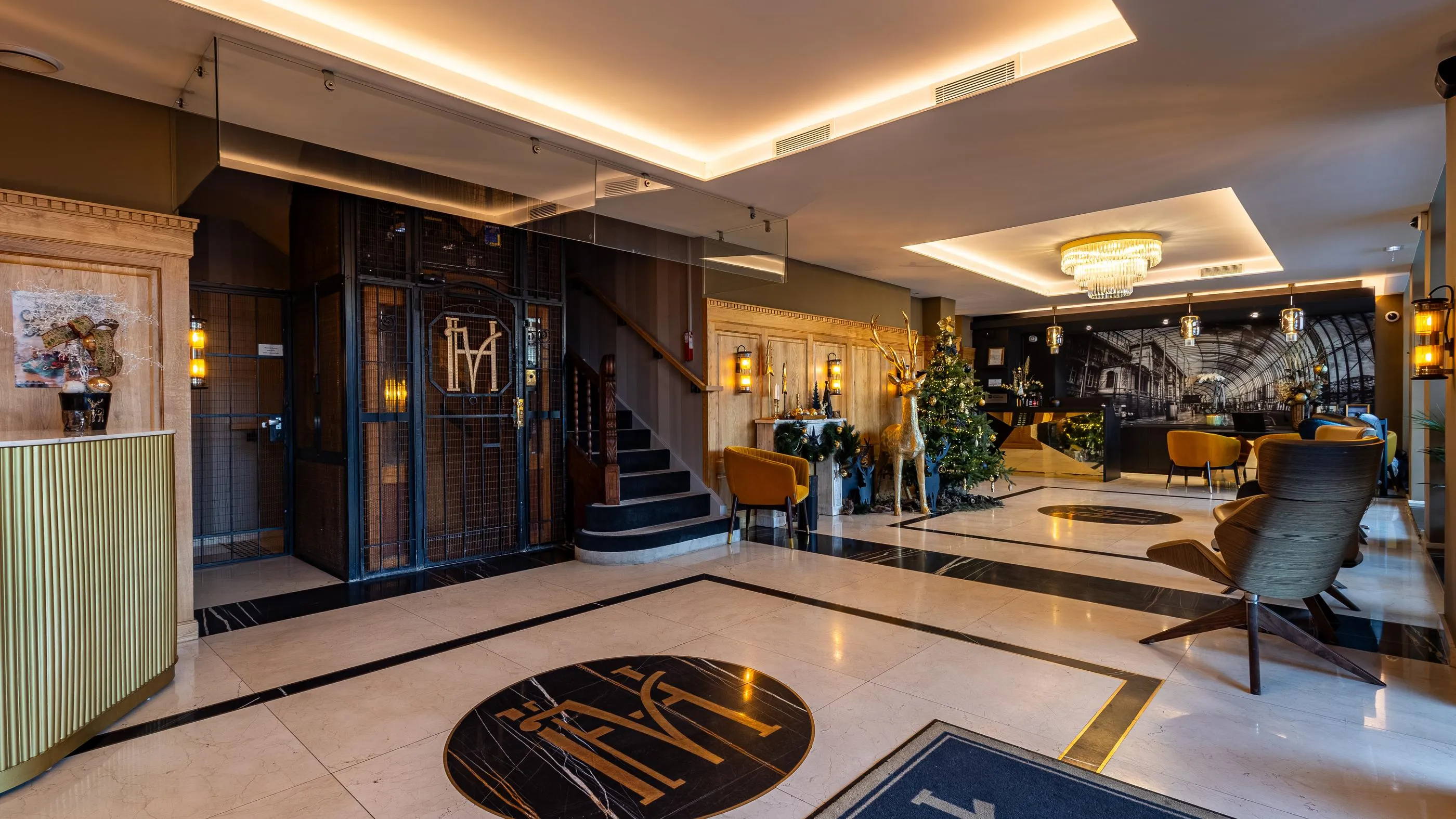 Lobby d'un hôtel avec un bar, des fauteuils, des décorations de Noël et un escalier central